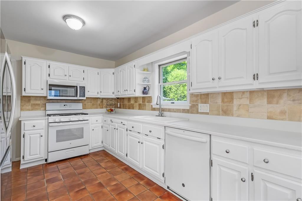 449 Nelson Ferry Road Decatur, GA 30030 - Photo 10 of 29 a kitchen with cabinets appliances a sink and a window