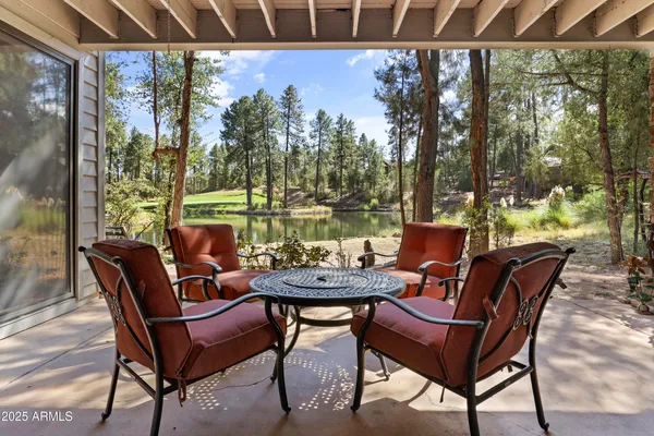 a view of a chairs and table in patio with a yard