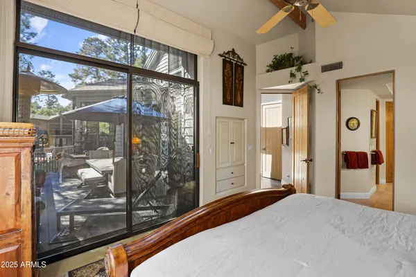 a bedroom with wooden floor and windows