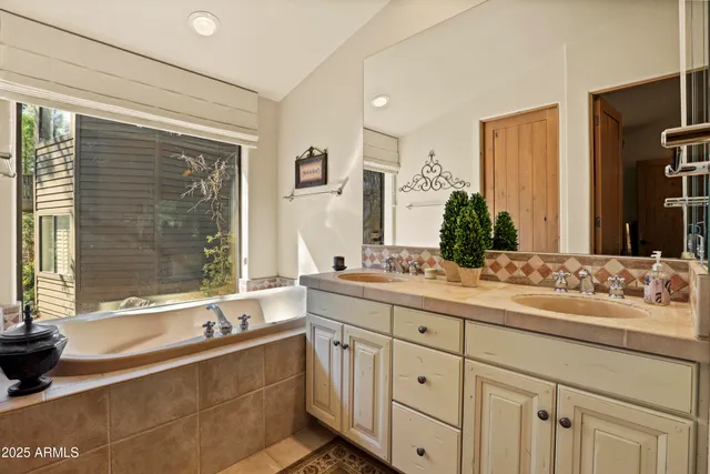 a bathroom with a granite countertop sink mirror and a bathtub