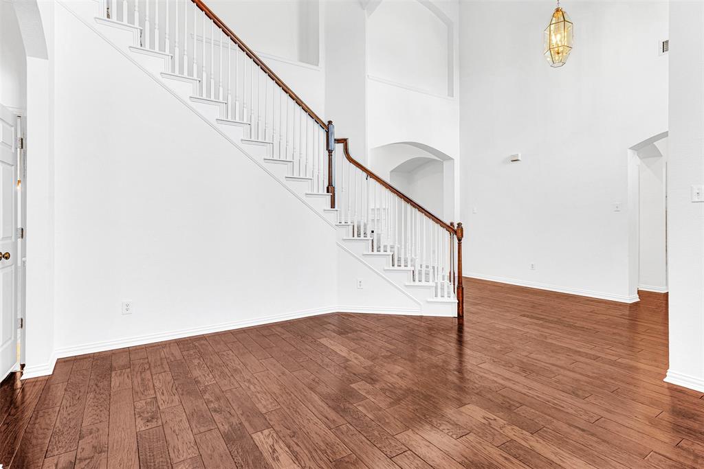 4332 Risinghill Drive Plano, TX 75024 - Photo 13 of 29 The sweeping staircase adds a fascinating focal point to the formal living room, showcasing all the art niches and other architectural features of the home.