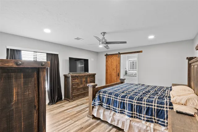 a bedroom with a large bed and flat tv screen