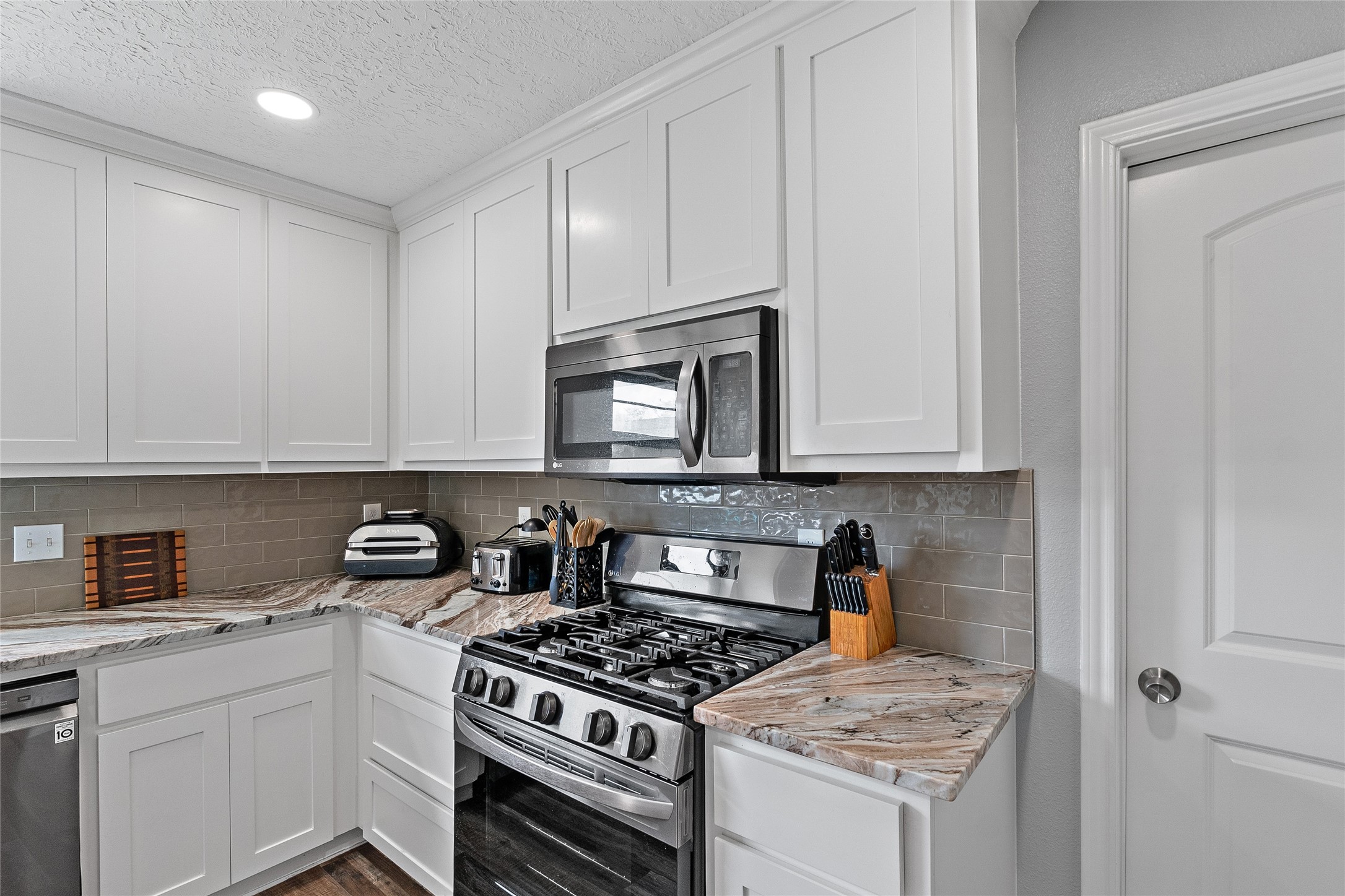 11050 Antioch Road Midway, TX 75852 - Photo 9 of 34 a kitchen with white cabinets and appliances