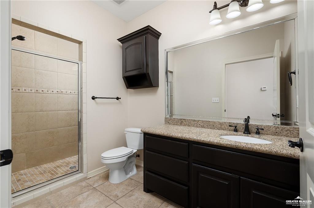511 Mi Vida Street Weslaco, TX 78596 - Photo 11 of 13 a bathroom with a granite countertop sink a toilet and shower