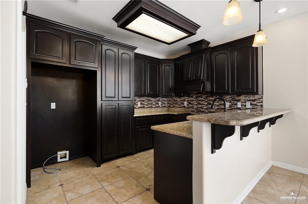 511 Mi Vida Street Weslaco, TX 78596 - Photo 6 of 13 a kitchen with stainless steel appliances granite countertop a refrigerator and a stove