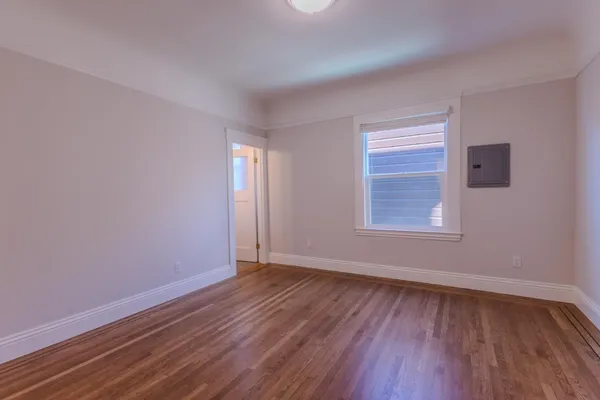 wooden floor in an empty room with a window