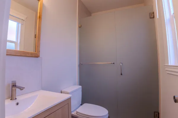 a bathroom with a sink a toilet and a mirror