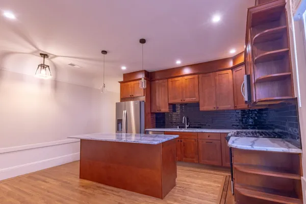 a kitchen with stainless steel appliances kitchen island granite countertop a sink and cabinets