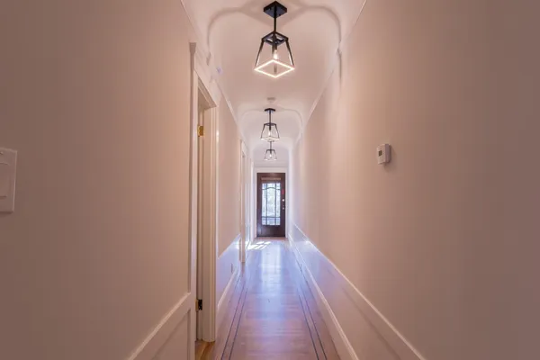 a view of a hallway with wooden floor and staircase