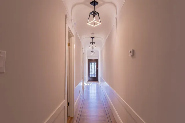 a view of a hallway with wooden floor and staircase