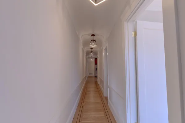 a view of a hallway with wooden floor and stairs