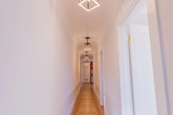 a view of a hallway with wooden floor and staircase