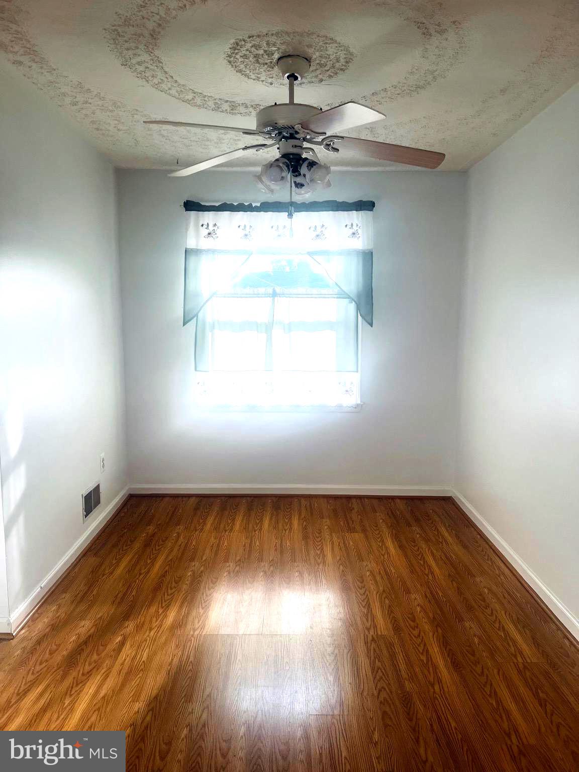 4457 Fenor Road Halethorpe, MD 21227 - Photo 2 of 29 an empty room with wooden floor chandelier and windows