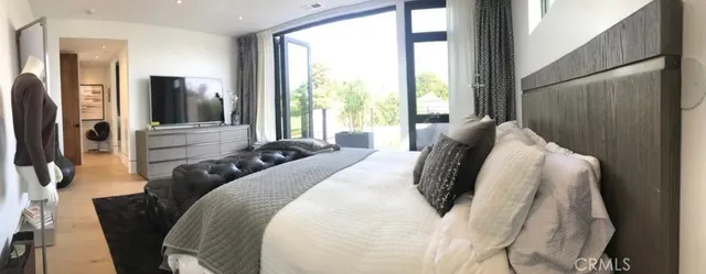 a bedroom with furniture and a large window