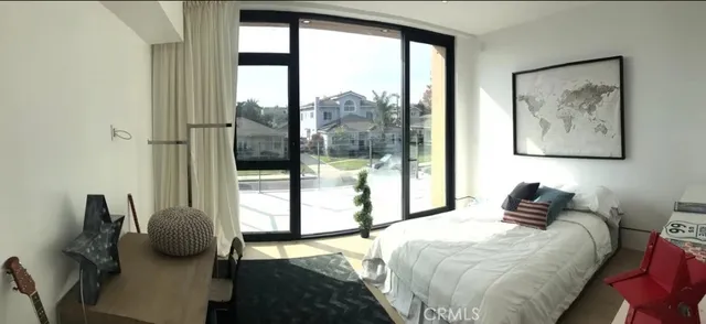 a bedroom with furniture and a large window