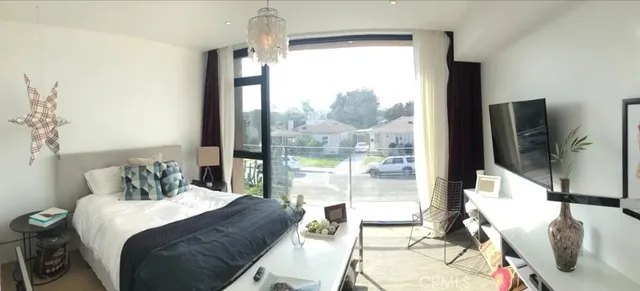 a bedroom with a bed and large windows