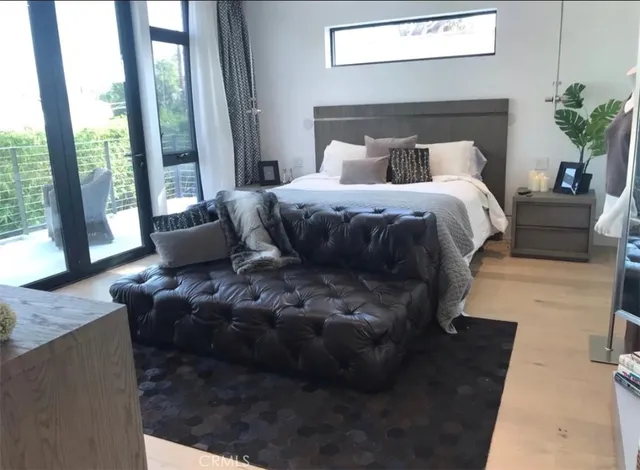 a bedroom with bed and a large window