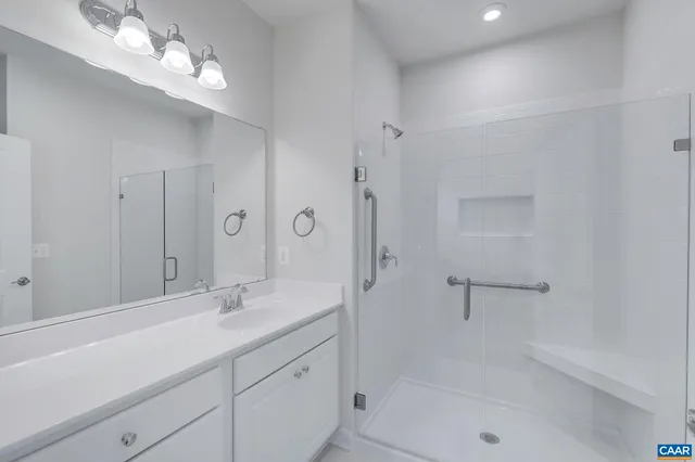 a bathroom with a shower sink large mirror and vanity