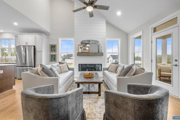 a dining room with wooden floor a chandelier a wooden table and chairs
