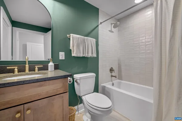 a bathroom with a toilet sink vanity and mirror