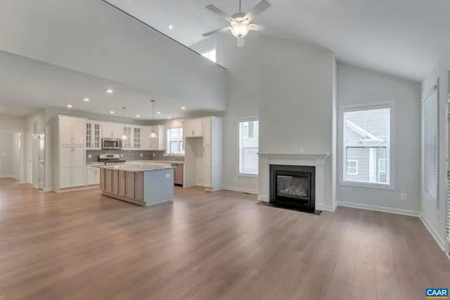 a view of kitchen with granite countertop kitchen island wooden floor and a fireplace