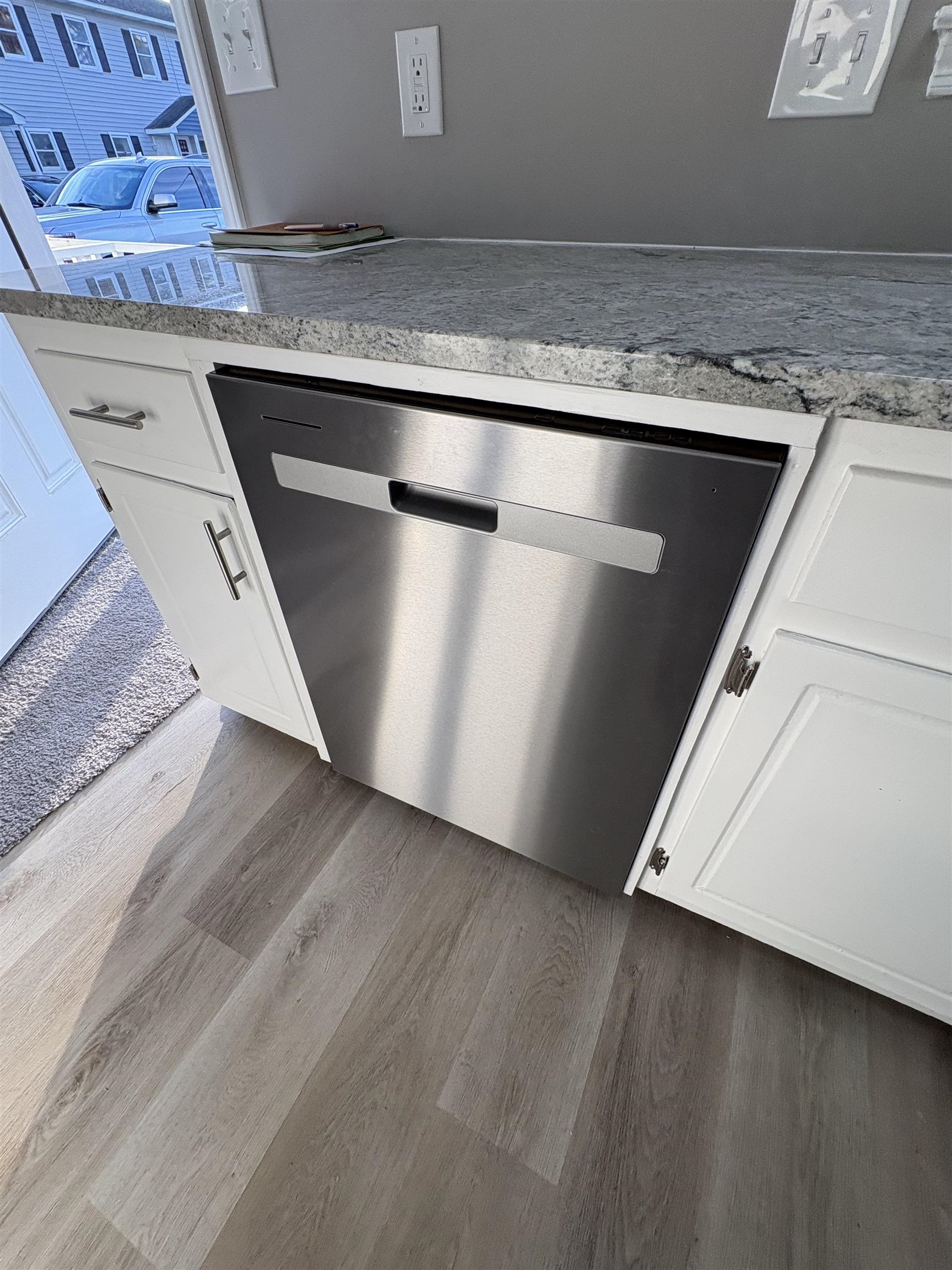 4641 Socastee Boulevard, Unit D1 Myrtle Beach, SC 29588 - Photo 12 of 12 Kitchen view of dishwasher, white cabinets, wood finished floors, and light stone counters