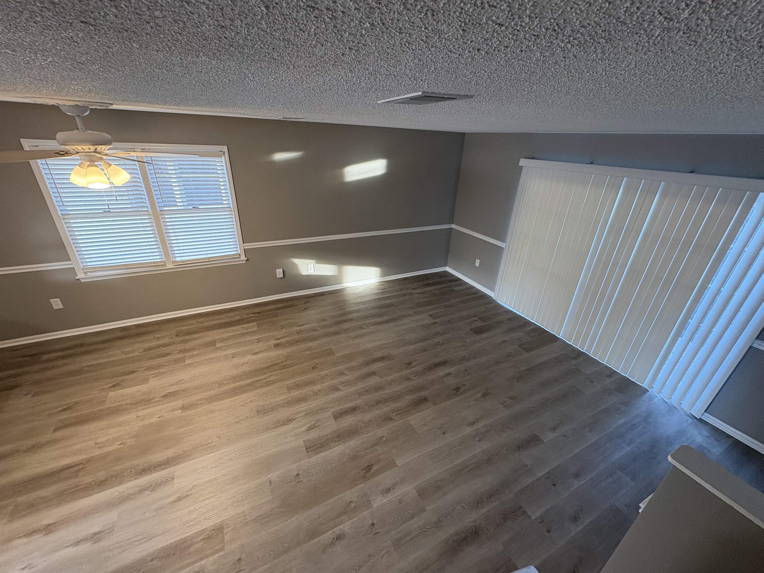 4641 Socastee Boulevard, Unit D1 Myrtle Beach, SC 29588 - Photo 9 of 12 Empty room featuring wood finished floors, a textured ceiling, and ceiling fan