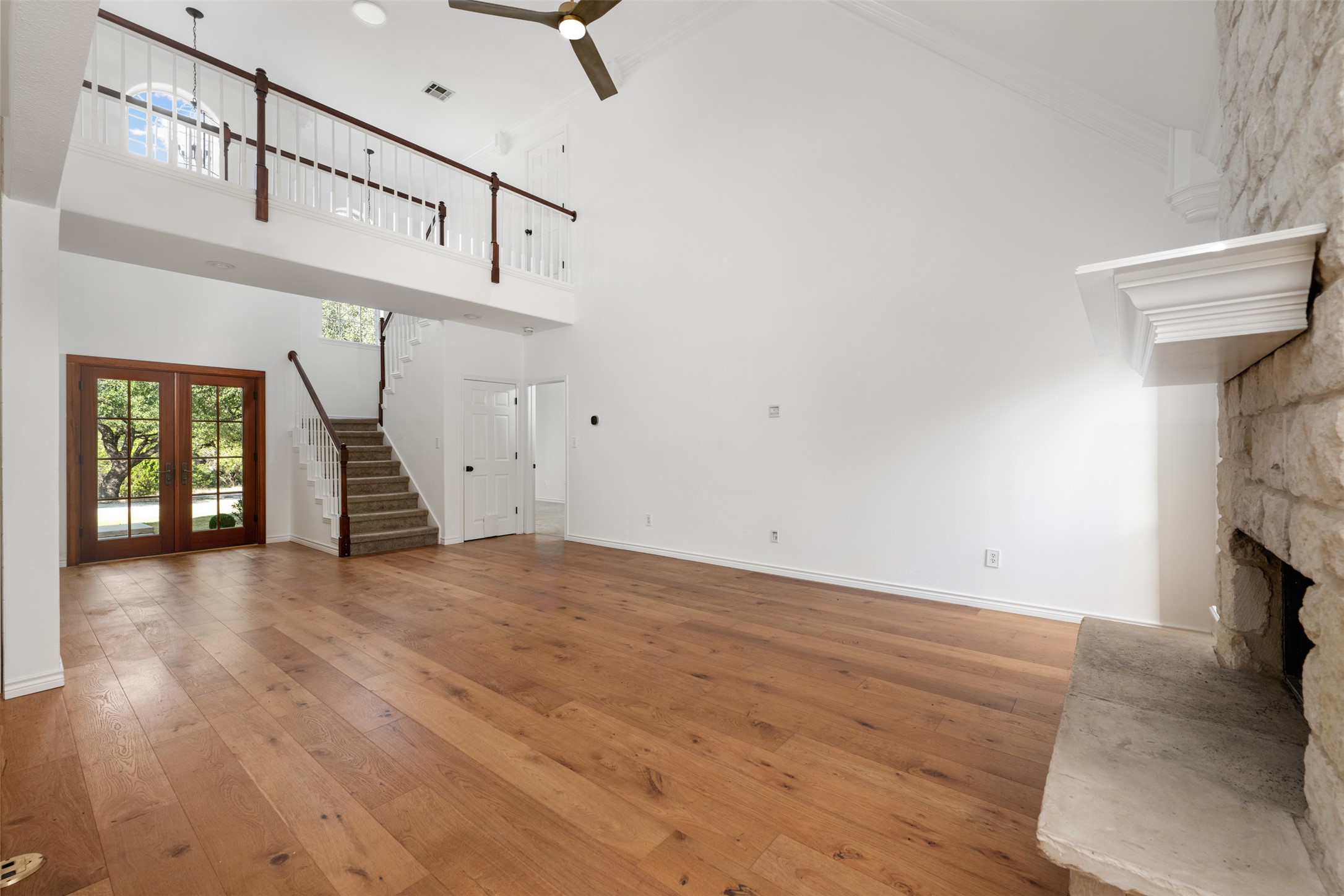 72 Crazy Cross Road Wimberley, TX 78676 - Photo 10 of 35 Rich hardwood floors complement the soaring vaulted ceiling and stone fireplace in this great room.