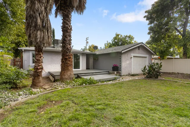 a view of a house with backyard and sitting area