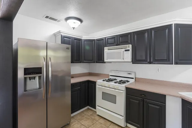 a kitchen with cabinets and white stainless steel appliances
