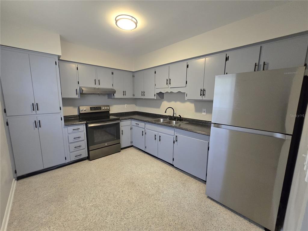 215 Clemons Road Brandon, FL 33510 - Photo 4 of 8 a kitchen with stainless steel appliances granite countertop white refrigerator stove a sink and dishwasher
