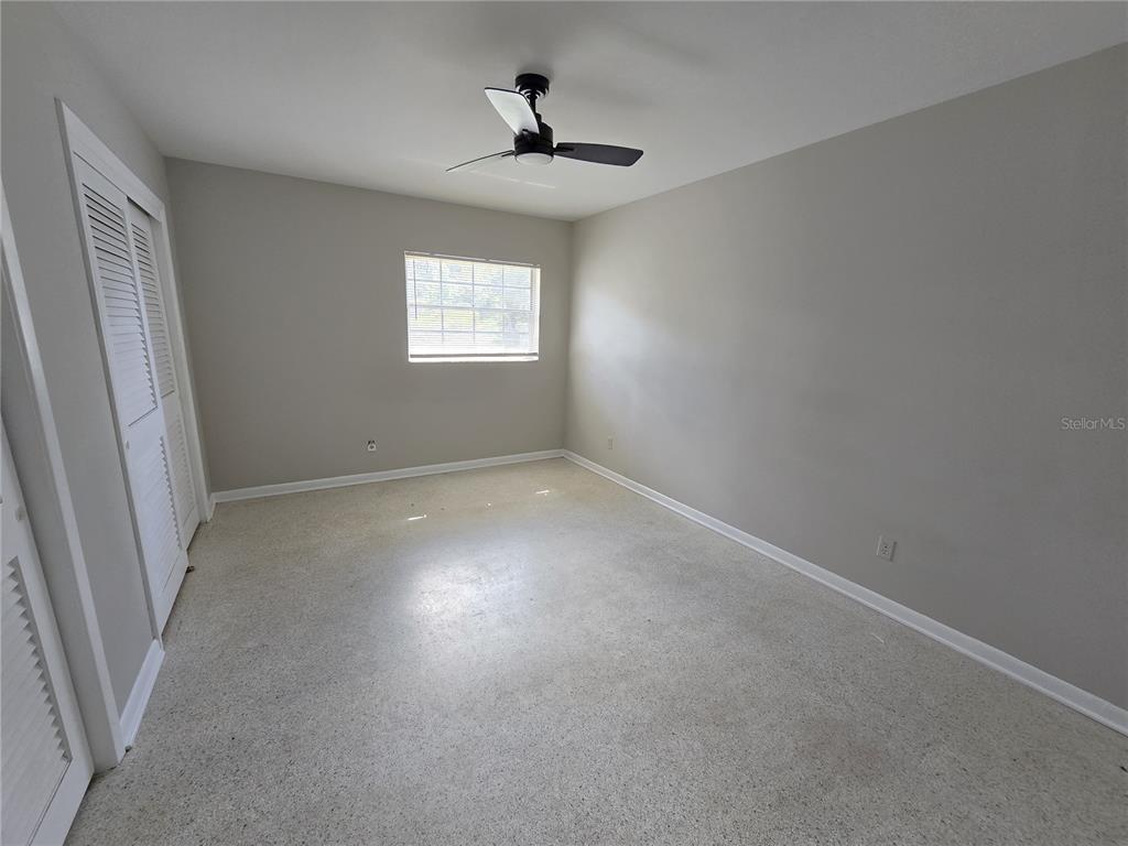 215 Clemons Road Brandon, FL 33510 - Photo 6 of 8 an empty room with windows and ceiling fan