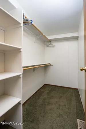 an empty room with closet and a hallway
