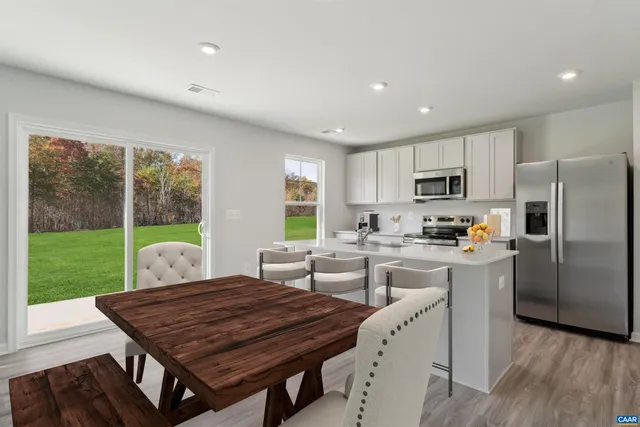 a kitchen with a table chairs refrigerator and cabinets
