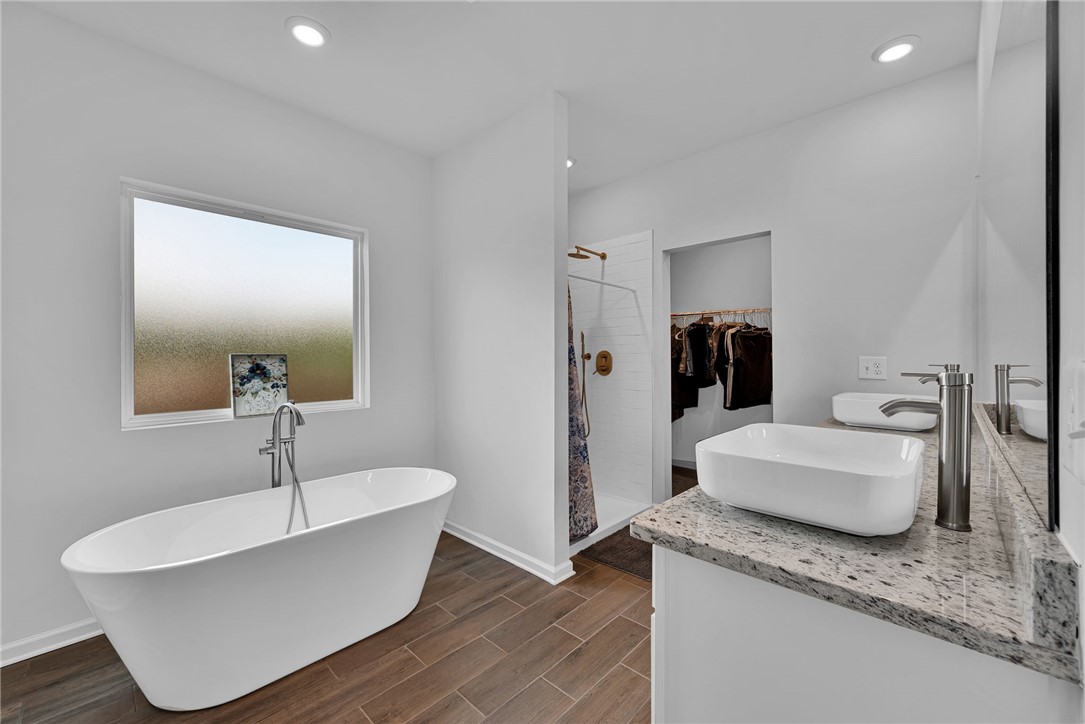 300 Clinkscales Road Anderson, SC 29624 - Photo 20 of 40 Luxurious freestanding tub with floor-mounted faucet in a modern bathroom.