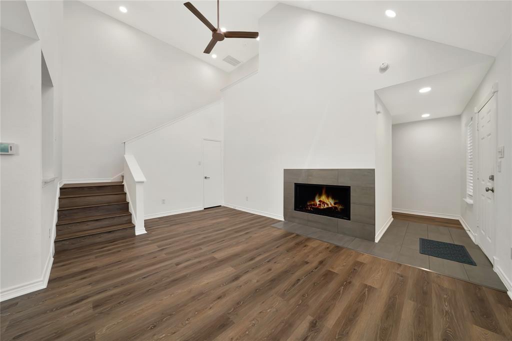 2909 Normandy Court Euless, TX 76039 - Photo 8 of 36 an empty room with wooden floor a fireplace and windows