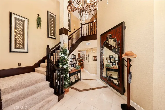 a dining room with wooden floor a chandelier a wooden table and chairs
