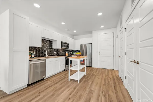 a kitchen with a refrigerator a sink a counter and cabinets