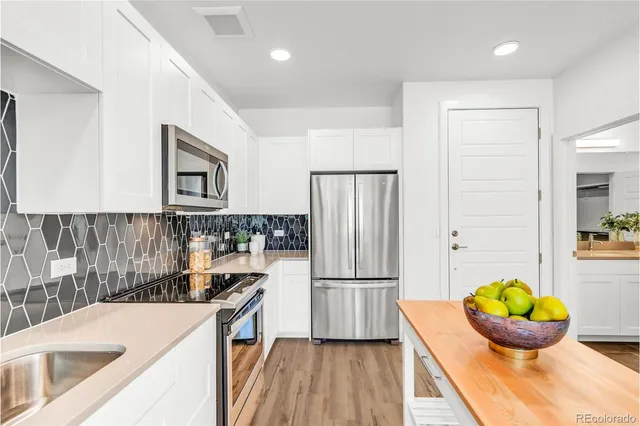a room with granite countertop a white sink and cabinets