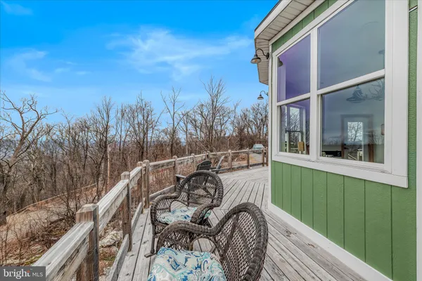 a view of a balcony with two chairs and wooden floor