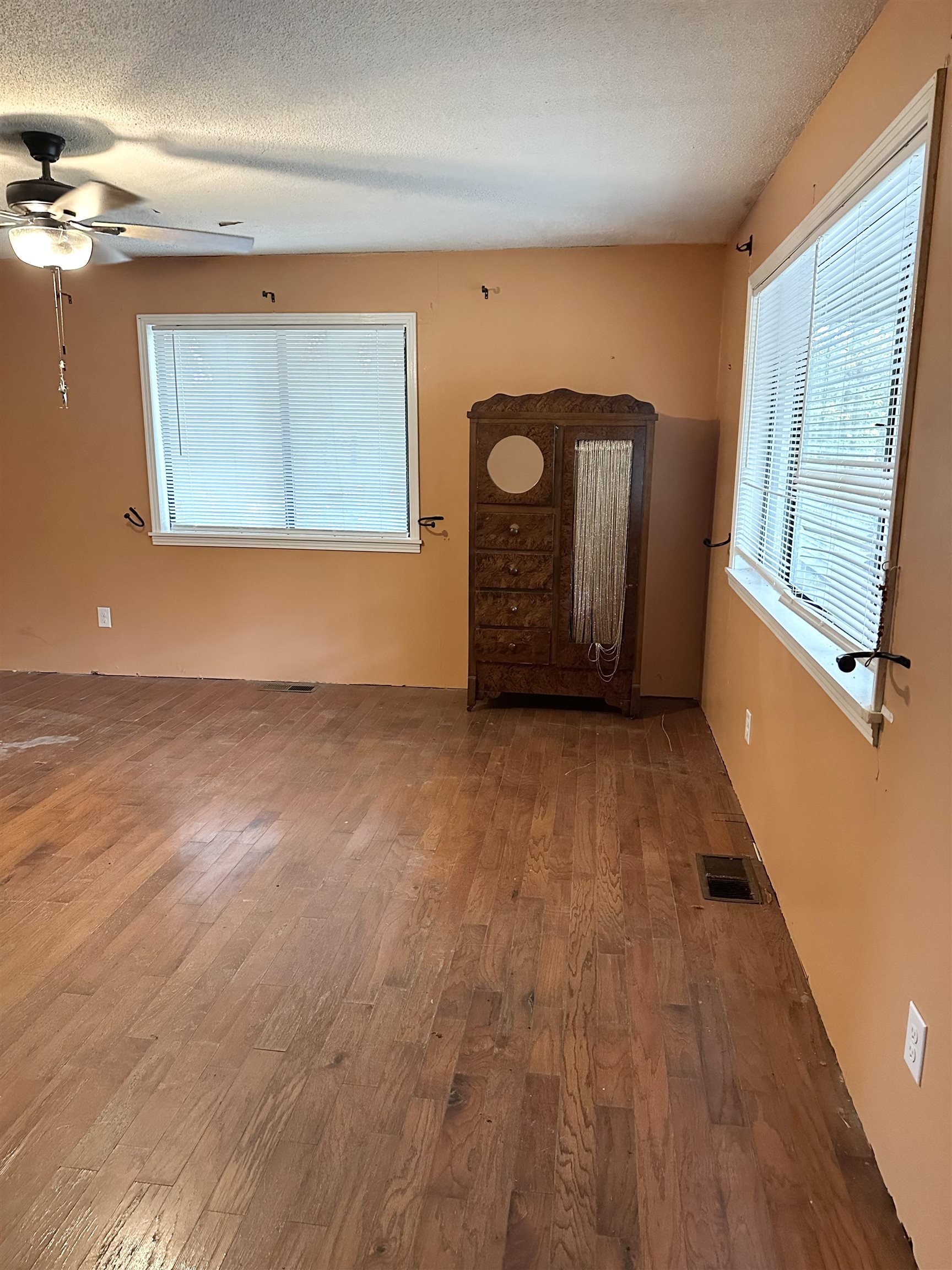 53 Crabtree Road Selmer, TN 38375 - Photo 3 of 28 Unfurnished living room with wood finished floors, a textured ceiling, and a ceiling fan