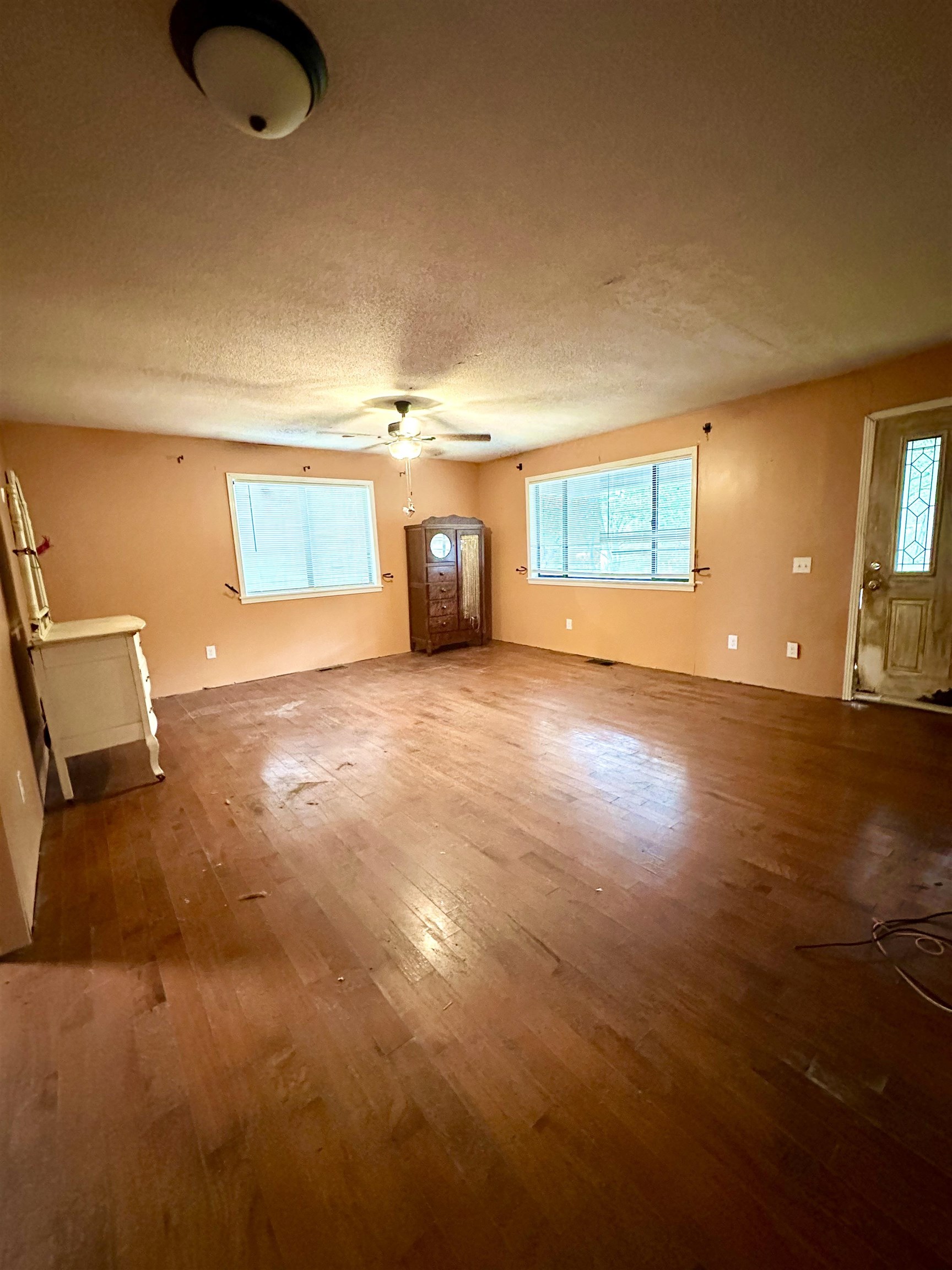53 Crabtree Road Selmer, TN 38375 - Photo 5 of 28 Unfurnished living room featuring wood finished floors and a textured ceiling