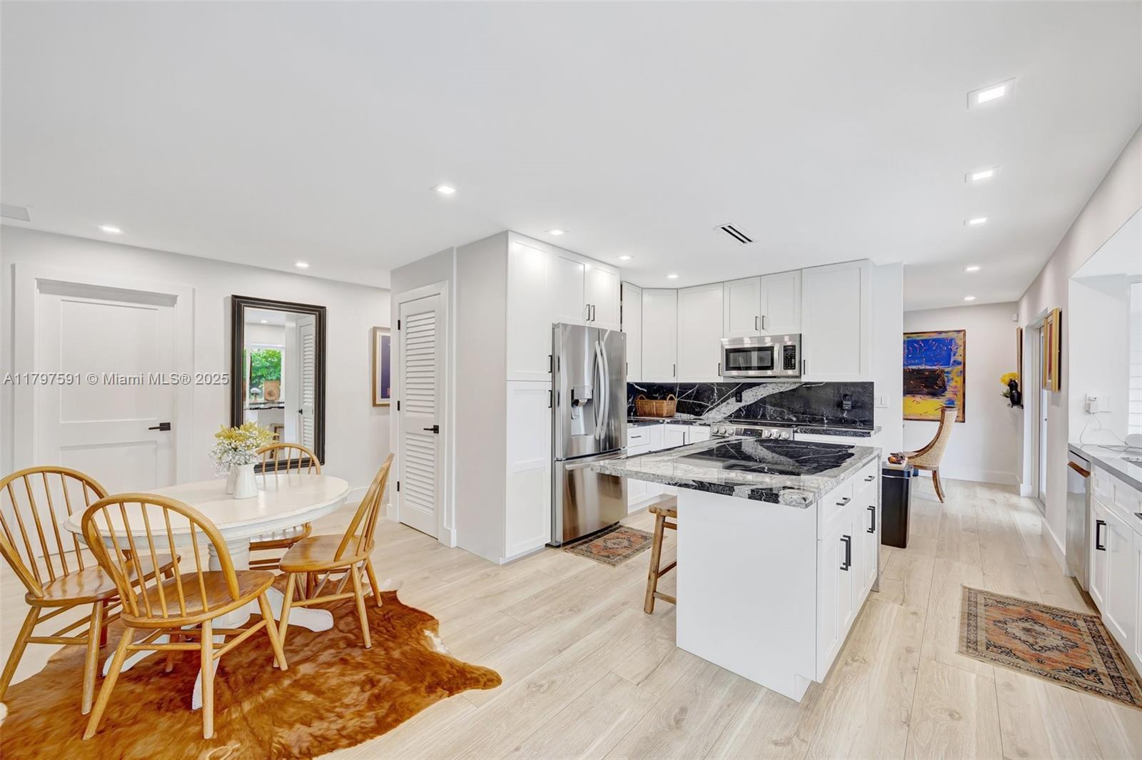 9547 Southwest 59th Terrace Miami, FL 33173 - Photo 14 of 51 a kitchen with stainless steel appliances kitchen island granite countertop a sink and cabinets