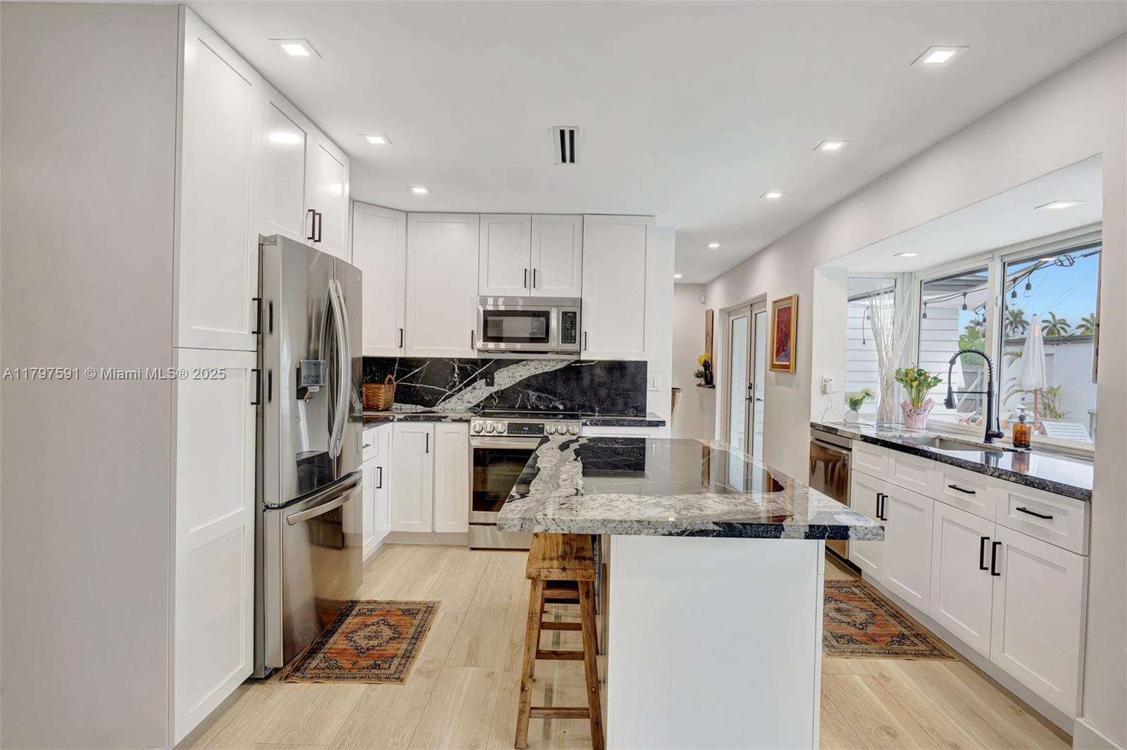 9547 Southwest 59th Terrace Miami, FL 33173 - Photo 15 of 51 a kitchen with kitchen island stainless steel appliances cabinets a sink and a counter top space