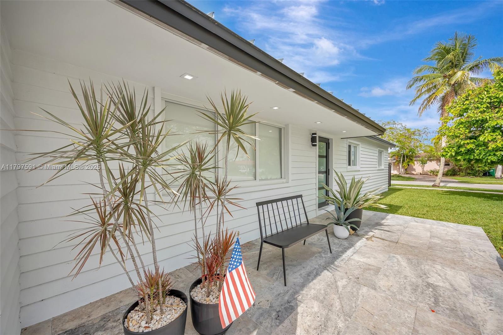 9547 Southwest 59th Terrace Miami, FL 33173 - Photo 2 of 51 a porch with a bench and potted plants