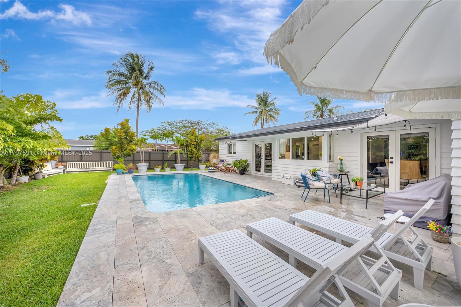 9547 Southwest 59th Terrace Miami, FL 33173 - Photo 40 of 51 a view of a patio with couches and table and chairs with plants and palm trees
