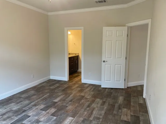 a view of empty room with wooden floor