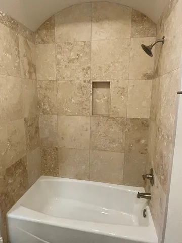 a bathroom with a shower and a bath tub