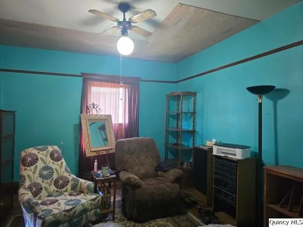 a living room with furniture a chandelier and a window