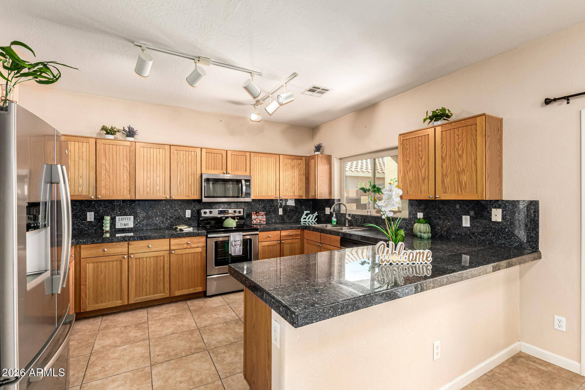 25660 West Dunlap Road Buckeye, AZ 85326 - Photo 11 of 40 a kitchen with stainless steel appliances granite countertop a sink counter space cabinets and a counter top space